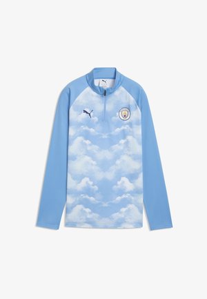 Langærmet lyseblå sportstop med sky-mønster, Manchester City-logo på brystet, Puma-logo og kvart lynlåsekrave.