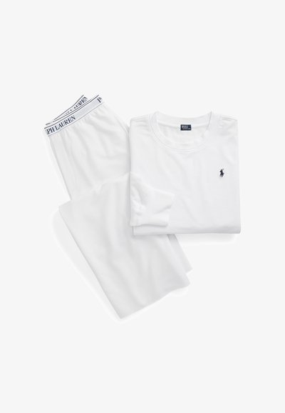 Λευκό πουκάμισο μακρυμάνικο με το λογότυπο Polo Ralph Lauren σε ναυτικό μπλε, διπλωμένο δίπλα σε λευκό παντελόνι με ζώνη μέσης με το λογότυπο Polo Ralph Lauren.