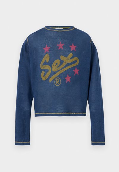 Μπλε μακρυμάνικη μπλούζα με κίτρινο κείμενο «Sex» και πέντε κόκκινα αστέρια στο μπροστινό μέρος, με κίτρινες ραφές στα τελειώματα του γιακά, των μανσετών και του κάτω μέρους.