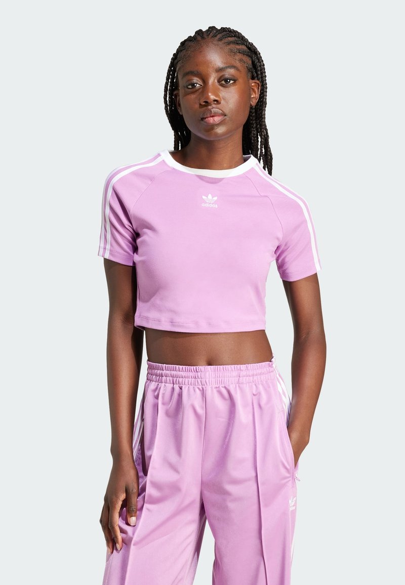 Light purple cropped athletic t-shirt with white trim, short sleeves, and Adidas logo; paired with matching light purple sweatpants.