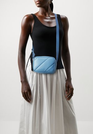Borsa a tracolla azzurro chiaro in materiale liscio, con motivo a quadrati obliqui, chiusura a zip e tracolla regolabile. Ideale per un uso casual.