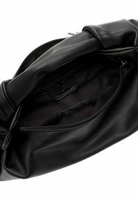 Juoda odinė rankinė su minkšta, lygiapusiška tekstūra. Turi užtrauktuko uždarymą ir kreivą rankeną. Vidus juodas, pagamintas iš audinio, su užtrauktuko kišene.