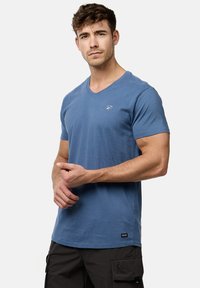 Blå bomulds V-hals T-shirt med et subtilt logo, korte ærmer og en løs pasform. Struktureret stof med en glat overflade.