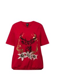 Camiseta de algodón roja con escote en forma de V, que presenta una ilustración de un ciervo en negro y dorado, rodeado de flores blancas y acentos de hojas en el dobladillo.