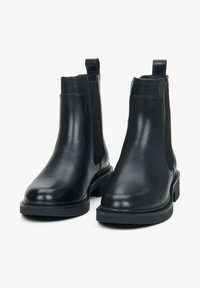 Černé kožené kotníkové boty s hladkým povrchem, elastickými bočními panely, poutky na patě a robustní gumovou podrážkou pro lepší přilnavost a stabilitu.