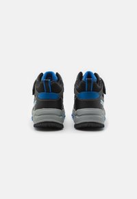 Schwarze und blaue Sportschuhe mit einer strukturierten Oberseite, Klettverschluss und grauer Gummisohle. Leichtes Design mit gepolstertem Kragen.
