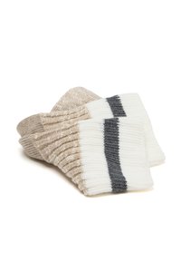 Calze lavorate a maglia con un design a costine. I colori includono strisce di crema, beige e grigio scuro. Texture morbida con un aspetto accogliente.