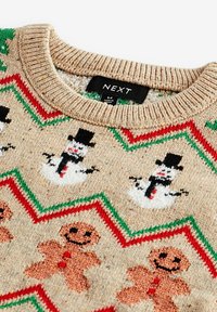 Sweater en tricot beige avec motifs de bonhommes de neige et de bonshommes en pain d'épice, accompagné d'accents en zigzag rouge et vert autour des motifs. Encolure côtelée et étiquette.