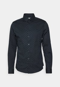 Tmavě modrá košile na knoflíky s malým zlatým diamantovým vzorem. Má klasický límeček a dlouhé rukávy s manžetami na knoflík.