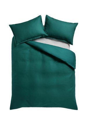 Türkisgrüner Bettbezug mit zwei passenden Kissen auf einem weißen Bett, eine Ecke des Bettbezugs ist zurückgefaltet, um das graue Laken darunter zu zeigen.