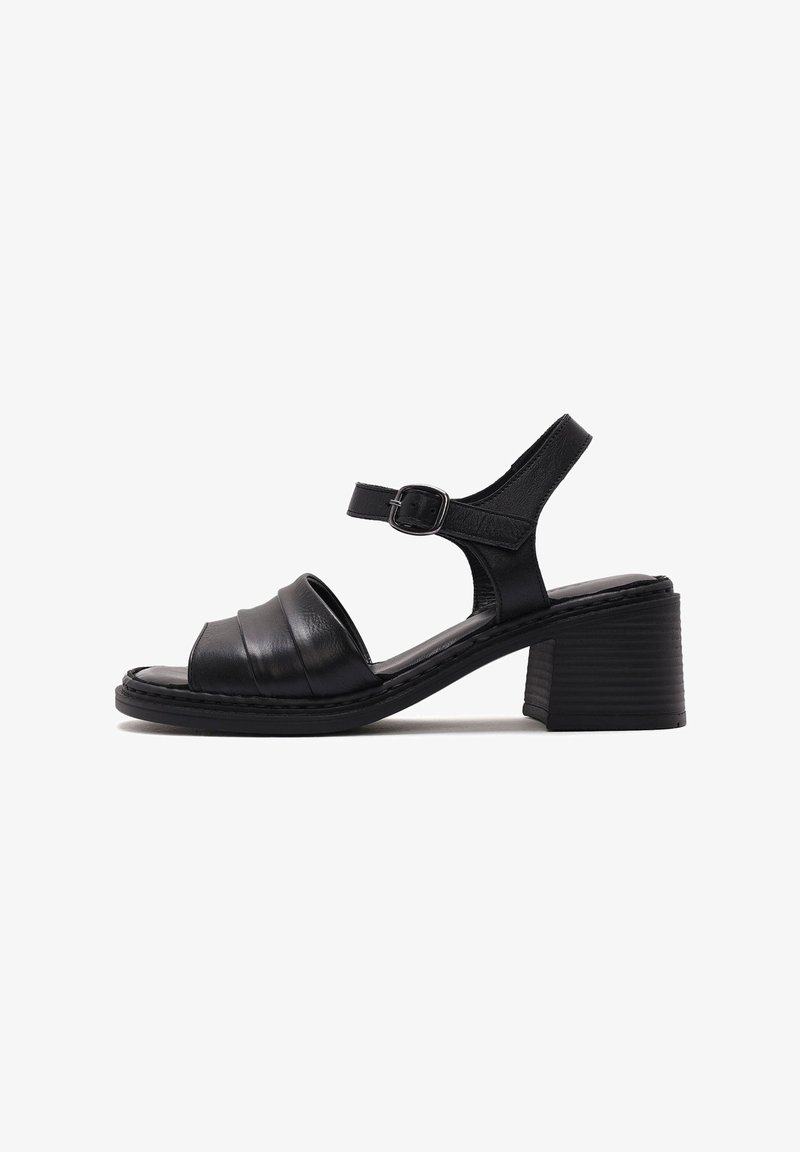 Sandalo in pelle nera con punta arrotondata, cinturino alla caviglia regolabile e tacco quadrato con texture. Presenta un design plissettato nella zona della punta.