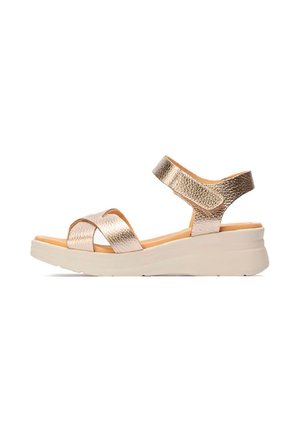 Sandalia de cuña en oro rosa metálico con dos tiras anchas sobre el pie y el tobillo, con una suela acolchada beige.
