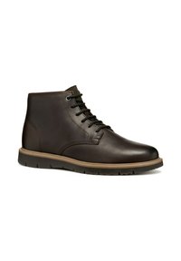 Bottine en cuir marron avec bout rond, fermeture à lacets et semelles en caoutchouc. Présente une texture lisse et de subtils accents de coutures.