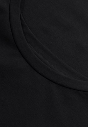 Czarna koszulka z gładkiego materia łu, z okrągłym dekoltem i subtelnym wykończeniem szwów wzdłuż krawędzi.