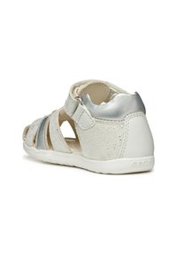 Sandalo bianco in pelle con accenti argentati, design aperto, texture perforata, cinturino regolabile e suola in gomma. Marchio Geox sul tallone.