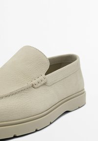 Beige Leder Slipper mit strukturiertem Obermaterial, runder Spitze und flexibler Gummisohle, minimaler Naht und subtilen Design.