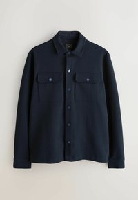 Dunkelblaues Hemd zum Knöpfen aus weichem Stoff, mit Kragen, zwei Brusttaschen und runden blauen Knöpfen. Insgesamt glatte Textur.