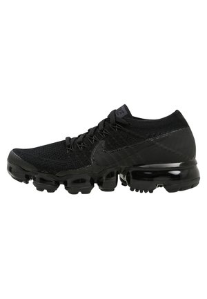 Černý běžecký boty Nike s pleteným svrškem, tkaničkami a segmentovanou podrážkou s vzduchovým polstrováním, pohled ze strany na bílém pozadí.