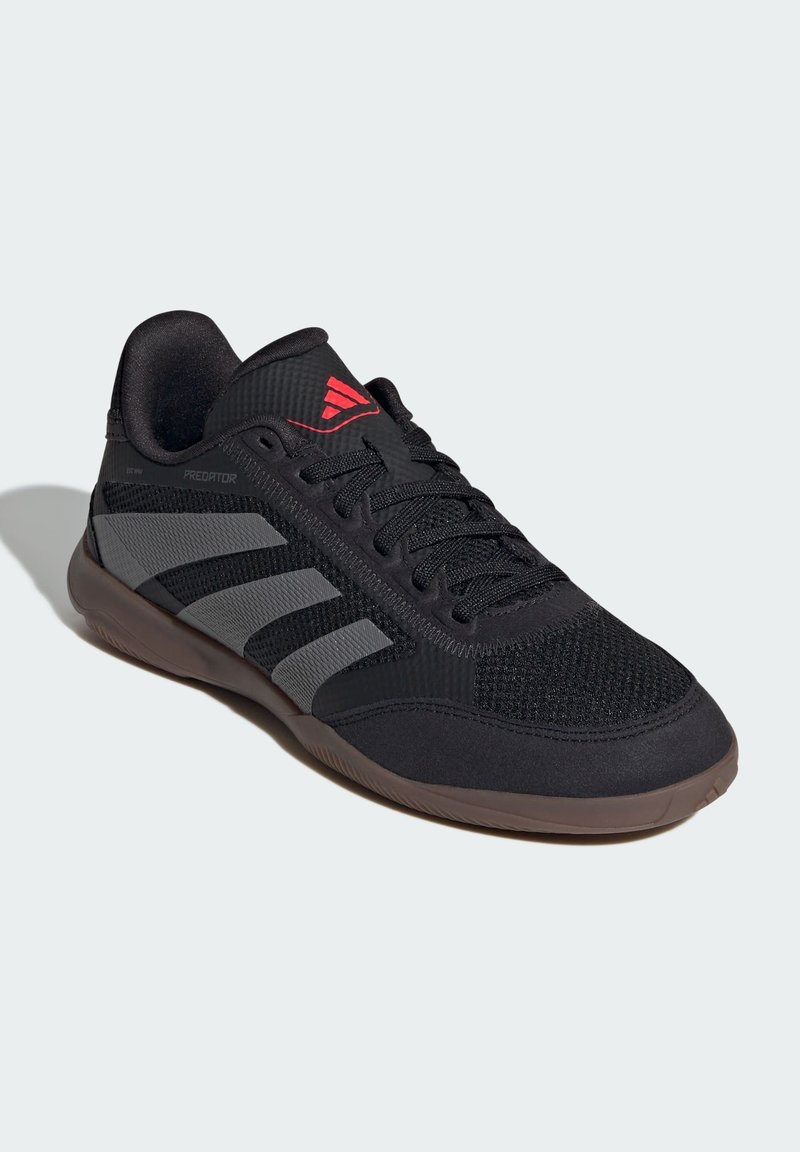 Schwarzer Sportschuh mit Obermaterial aus Mesh, grauen Streifen, gepolstertem Kragen und rotem Logo. Verfügt über eine Gummisohle, die für Grip und Langlebigkeit ausgelegt ist.