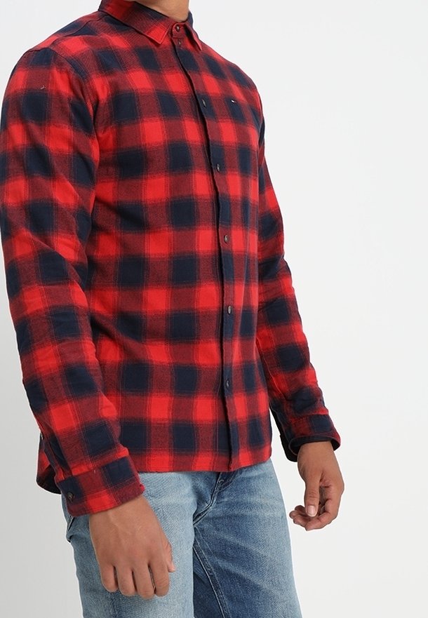 Chemise en flanelle à carreaux rouge et bleu marine, à manches longues, avec col boutonné, présentant une fermeture à boutons à l'avant et une coupe décontractée.