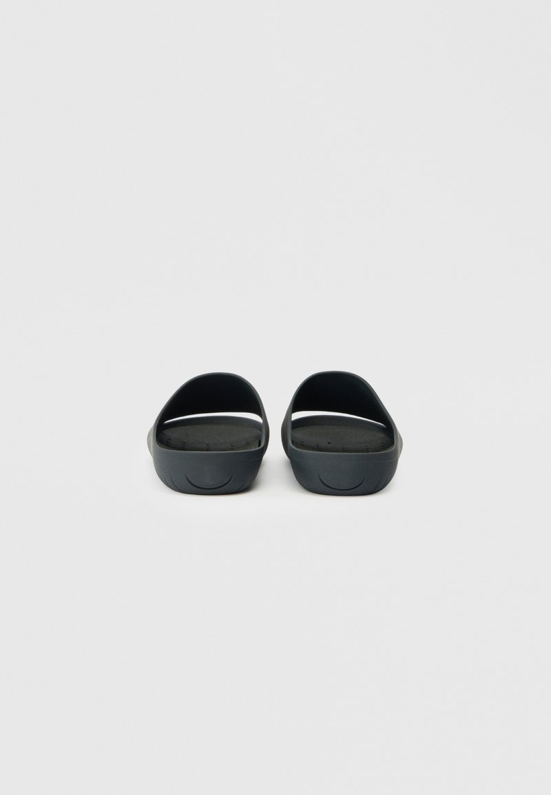 Schwarze Gummisandalen mit einem offenen Rücken, geschwungenem Design, strukturiertem Fußbett und dezenten Belüftungsöffnungen. Glatte Oberfläche und minimalistischer Stil.