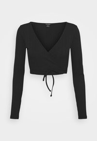 Top corto nero a maniche lunghe con texture a coste, scollatura a V e un fiocco in vita. Design semplice, senza motivi o dettagli.