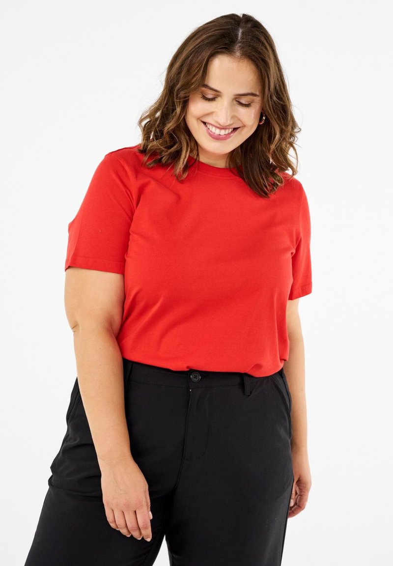 Raudoni trumpomis rankovėmis marškinėliai iš minkštos medvilnės, su apvalia kaklo linija. Derinami su laisvais juodos spalvos kelnėmis. Paprastas dizainas, be raštų.