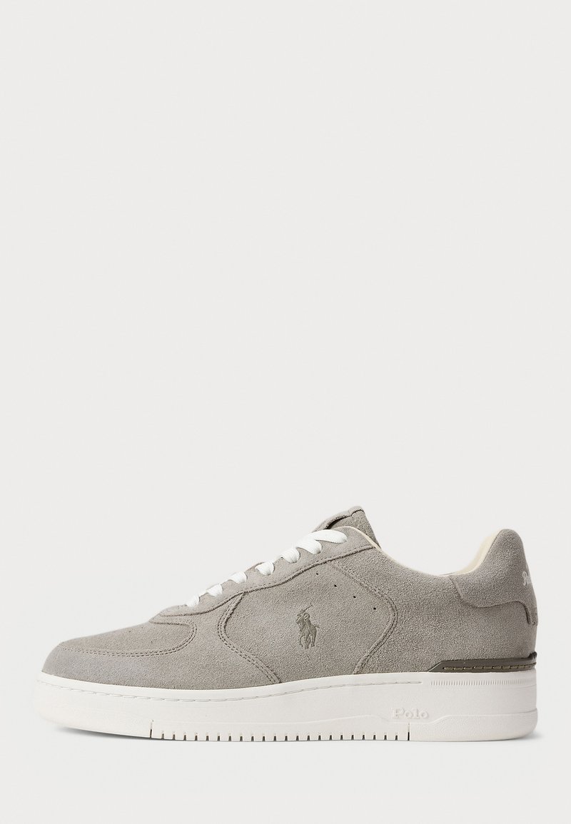 Sneaker bassa in suede grigio chiaro con lacci bianchi, logo discreto sul lato e suola spessa in gomma bianca.
