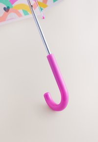 Parapluie coloré avec une poignée en plastique rose incurvée et une toile partiellement visible avec des motifs abstraits pastel.