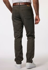 Ruske slim-fit hlače od mekih tkanina, s dva stražnja džepa i smešnim smešnim remenom. Nosi se s belim patikama.