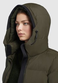 Isolierte Daunenjacke in Olivgrün mit einer großen Kapuze, Reißverschluss und kontrastierenden schwarzen Akzenten entlang des Kragens und des Reißverschlusses.