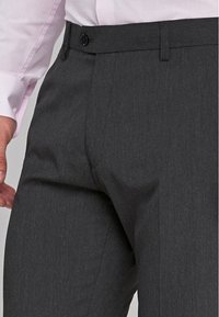 Pantalon gris ajusté en tissu lisse et texturé. Doté d'une fermeture à bouton à l'avant et de poches latérales. Design simple et classique.