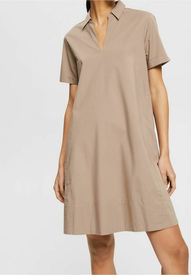Kurzärmliges, beiges Kleid mit Kragen und V-ausschnitt. Aus glattem Stoff gefertigt, mit lockerem Schnitt und geradem Saum.