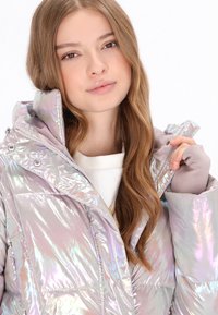 Irideszkáló világoslila pufi kabát kapucnival, elöl cipzárral, patentgombokkal és textúrált anyaggal.