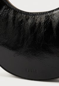 Borsa a mano in pelle nera con una finitura liscia e testurizzata. Presenta una forma circolare e il marchio "FURLA" in rilievo vicino al bordo inferiore.