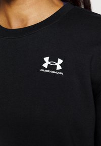 Black sweatshirt made of cotton blend, featuring a round neckline and embroidered white Under Armour logo on the chest.