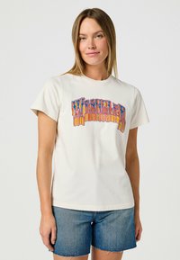 Crème-kleurig katoenen T-shirt met een multicolor "Wrangler" grafische print in retrostijl; korte mouwen, ronde halslijn, relaxte pasvorm.