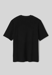 T-shirt noir en maille côtelée à manches courtes, avec un col rond et une coupe décontractée. Le tissu a une apparence douce et texturée.