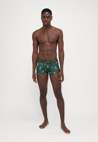 Grüne Boxershorts mit floralem Muster, ausgestattet mit einem schwarzen Bund, auf dem das Logo "POLO RALPH LAUREN" in Gold prangt. Weicher, dehnbarer Stoff.