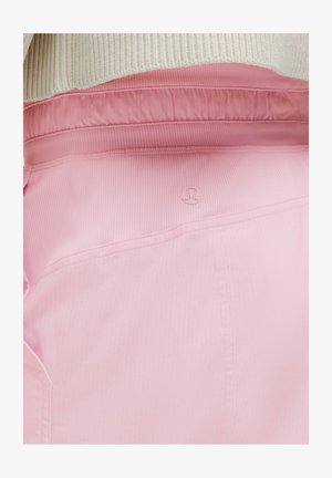 Rosa Sporthose mit geripptem Muster und elastischem Bund, mit einem kleinen Logo auf der hinteren Tasche.