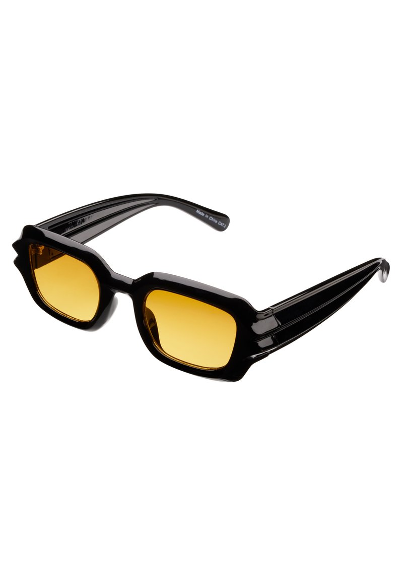Svarta överdimensionerade solglasögon med fyrkantiga gula linser, utrustade med tjocka vinklade bågar och randiga tasslar.