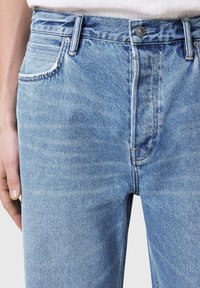 Jeanși din denim de culoare albastru deschis, cu un croi drect, design cu cinci buzunare, închidere cu nasture și o ușoară decolorare în textura materialului.
