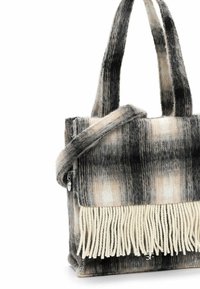 Bolso de lana con diseño de cuadros en tonos negro, blanco y beige, con dos asas y flecos de hilo blanco retorcido en el borde inferior.