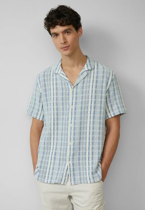 Chemise à manches courtes, à boutons, avec des rayures verticales bleues et blanches. Tissu léger et texturé. Col à encoches et coupe décontractée.