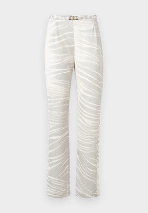 Pantaloni largi de culoare bej deschis, cu dungi albe abstracte în stil zebrat și o curea subțire albă cu cataramă aurie.