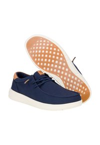Scarpe in tessuto blu navy con punta rotonda e linguetta corta, caratterizzate da accenti marrone chiaro e una suola in gomma bianca con grip testurizzato.