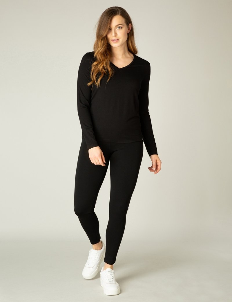 Zwarte lange mouw top met V-hals en aansluitende zwarte leggings. Draag het met witte sneakers, wat zorgt voor een slanke, gestroomlijnde silhouette en een gladde textuur.