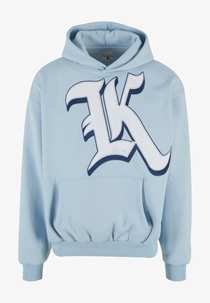 Ljusblå huvtröja med en stor broderad "K"-logotyp i vitt och marinblått, kängurufickor, ribbade muddar och midja. Mjuk tygtextur.