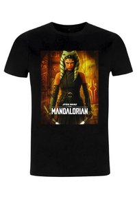 Czarna koszulka z centralnym nadrukiem postaci z "Gwiezdnych Wojen: The Mandalorian", z zielono-białymi paskowanymi nakryciem głowy i ciemnym strojem.