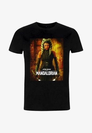 Sort T-shirt med et centralt grafik af en karakter fra "Star Wars: The Mandalorian," med grønt og hvidt stribet hovedgear og et mørkt outfit.